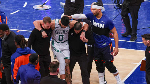 May 12, 2025; New York, New York, USA; Boston Celtics forward Jayson Tatum (0) is helped off the court by after an injury in the second half during game four of the second round for the 2025 NBA Playoffs as New York Knicks guard Josh Hart (3) gestures at Madison Square Garden. Tatum would leave the game with an injury after this play.