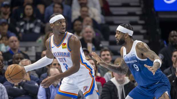 Nov 28, 2023; Minneapolis, Minnesota, USA; Oklahoma City Thunder guard Shai Gilgeous-Alexander (2) looks to pass around Minnesota Timberwolves guard Nickeil Alexander-Walker (9) in the second half at Target Center.