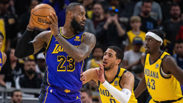 Los Angeles Lakers forward LeBron James (23) holds the ball while Indiana Pacers guard Tyrese Haliburton (0) defends in the first half at Gainbridge Fieldhouse.