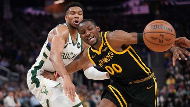Mar 6, 2024; San Francisco, California, USA; Golden State Warriors forward Jonathan Kuminga (00) loses control of the ball next to Milwaukee Bucks forward Giannis Antetokounmpo (34) in the third quarter at the Chase Center.