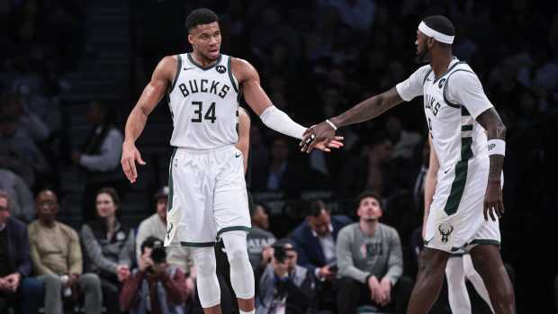 Dec 27, 2023; Brooklyn, New York, USA; Milwaukee Bucks forward Giannis Antetokounmpo (34) slaps hands with forward Bobby Portis (9) during the first half against the Brooklyn Nets at Barclays Center.