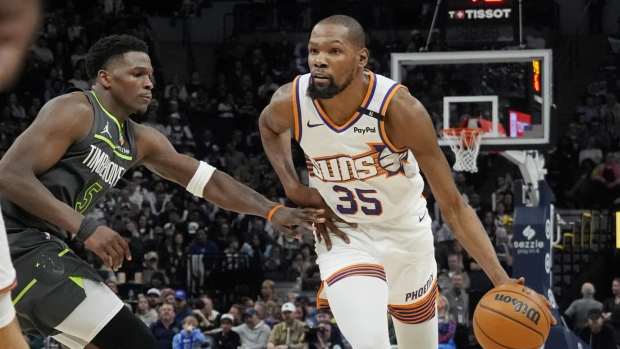 Mar 28, 2025; Minneapolis, Minnesota, USA; Phoenix Suns forward Kevin Durant (35) brings the ball up as Minnesota Timberwolves guard Anthony Edwards (5) defends him in the fourth quarter at Target Center.