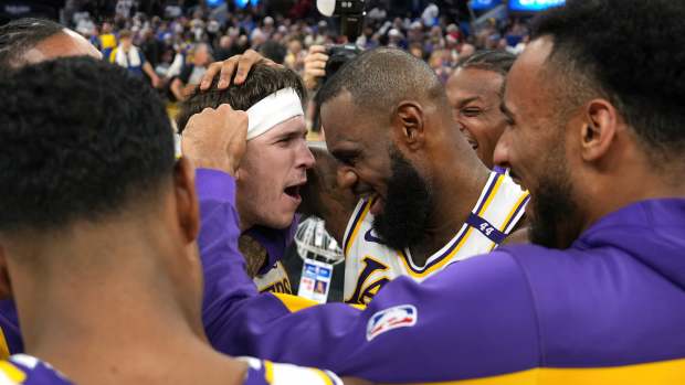 Dec 25, 2024; San Francisco, California, USA; Los Angeles Lakers guard Austin Reaves (center left) is congratulated by forward LeBron James (center right) after making the game-winning basket to defeat the Golden State Warriors at Chase Center. Mandatory Credit: Darren Yamashita-Imagn Images