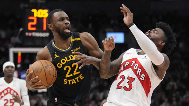 Jan 13, 2025; Toronto, Ontario, CAN; Toronto Raptors guard Jamal Shead (23) gets knocked over after colliding with Golden State Warriors forward Andrew Wiggins (22) during the second half at Scotiabank Arena. Mandatory Credit: John E. Sokolowski-Imagn Images