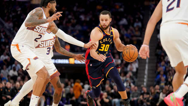 Jan 31, 2025; San Francisco, California, USA; Golden State Warriors guard Stephen Curry (30) dribbles the ball next to Phoenix Suns center Nick Richards (2) in the fourth quarter at the Chase Center. Mandatory Credit: Cary Edmondson-Imagn Images  