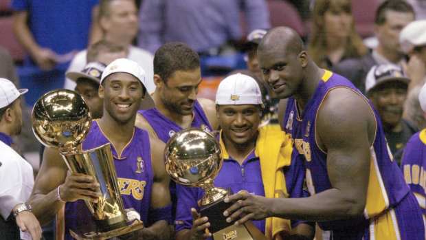 Los Angeles Lakers Kobe Bryant, Lindsay Hunter and Shaquille O'Neal hold championship trophies after winning Game 4 of the NBA Finals at The Meadowlands.