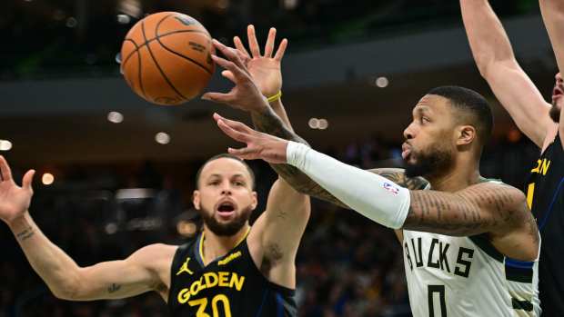  Milwaukee Bucks guard Damian Lillard (0) passes the ball away from Golden State Warriors guard Stephen Curry (30) in the fourth quarter at Fiserv Forum. Mandatory Credit: Benny Sieu-Imagn Images