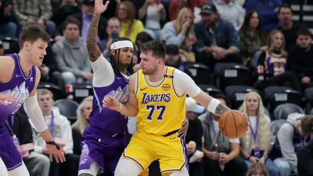 Feb 12, 2025; Salt Lake City, Utah, USA; Los Angeles Lakers guard Luka Doncic (77) dribbles against Utah Jazz guard Jordan Clarkson (00) during the second half at Delta Center. Mandatory Credit: Chris Nicoll-Imagn Images  