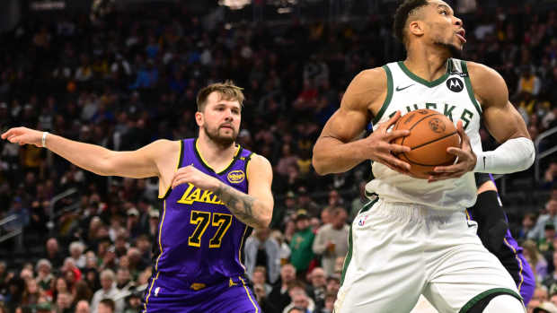 Milwaukee Bucks forward Giannis Antetokounmpo (34) controls the ball against Los Angeles Lakers guard Luka Doncic (77) in the first quarter at Fiserv Forum. Mandatory Credit: Benny Sieu-Imagn Images