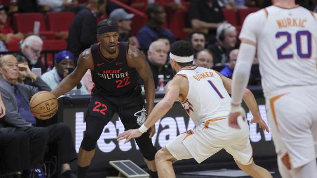 Miami Heat forward Jimmy Butler (22) dribbles the basketball as Phoenix Suns guard Devin Booker (1) defends during the third quarter at Kaseya Center. Mandatory Credit: Sam Navarro-Imagn Images