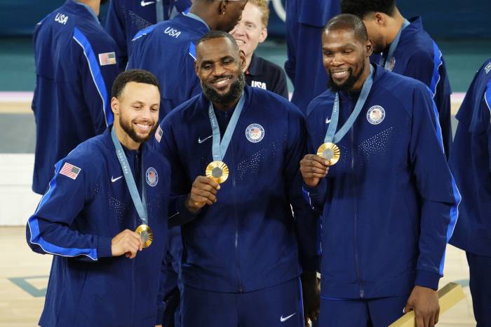 United States shooting guard Stephen Curry (4) and guard LeBron James (6) and guard Kevin Durant (7) celebrate with their gold medals on the podium after defeating France in the men's basketball gold medal game during the Paris 2024 Olympic Summer Games at Accor Arena. Mandatory Credit: Rob Schumacher-Imagn Images