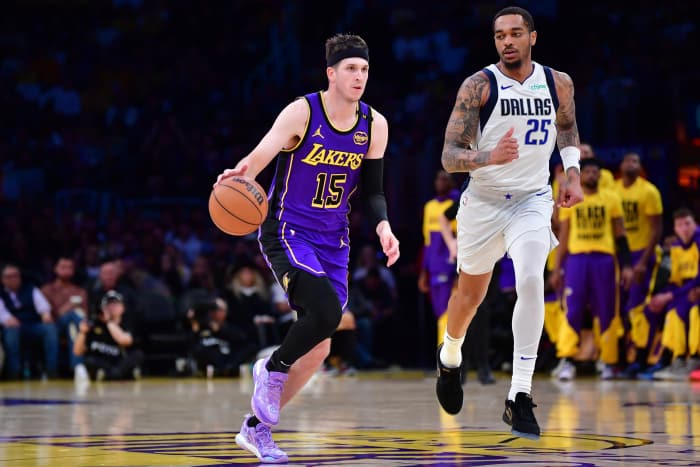 Los Angeles Lakers guard Austin Reaves (15) dribbles the ball past Dallas Mavericks forward P.J. Washington (25) during the second half at Crypto.com Arena. Mandatory Credit: Gary A. Vasquez-Imagn Images