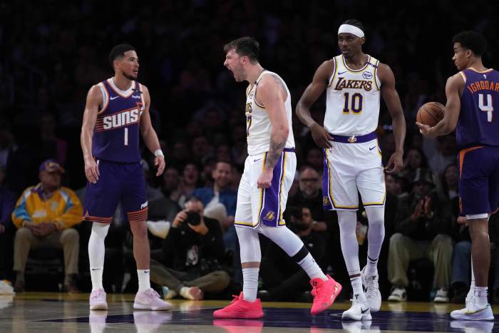 Mar 16, 2025; Los Angeles, California, USA; Los Angeles Lakers guard Luka Doncic (77) and center Christian Koloko (10) react as Phoenix Suns guard Devin Booker (1) watches in the second half at Crypto.com Arena. Mandatory Credit: Kirby Lee-Imagn Images