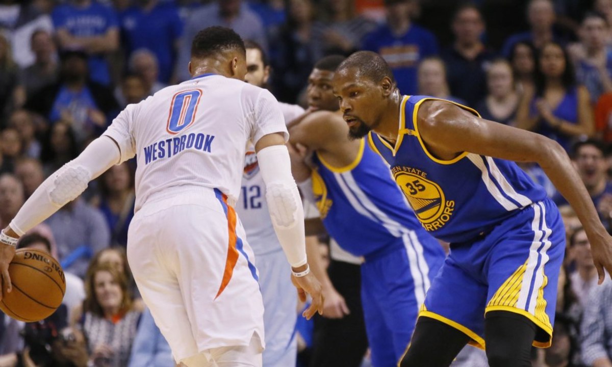 Golden State Warriors forward Kevin Durant (35) defends as Oklahoma City Thunder guard Russell Westbrook (0) dribbles in the first quarter of an NBA basketball game in Oklahoma City, Saturday, Feb. 11, 2017. (AP Photo/Sue Ogrocki) ORG XMIT: OKSO111