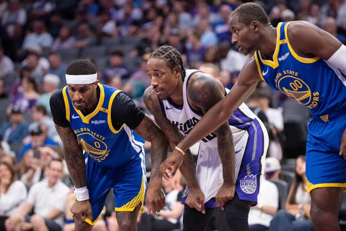 Oct 9, 2024; Sacramento, California, USA; Golden State Warriors guard Gary Payton II (0) and forward Jonathan Kuminga (00) defend against Sacramento Kings forward DeMar DeRozan (10) during a free throw attempt in the second quarter at Golden 1 Center.