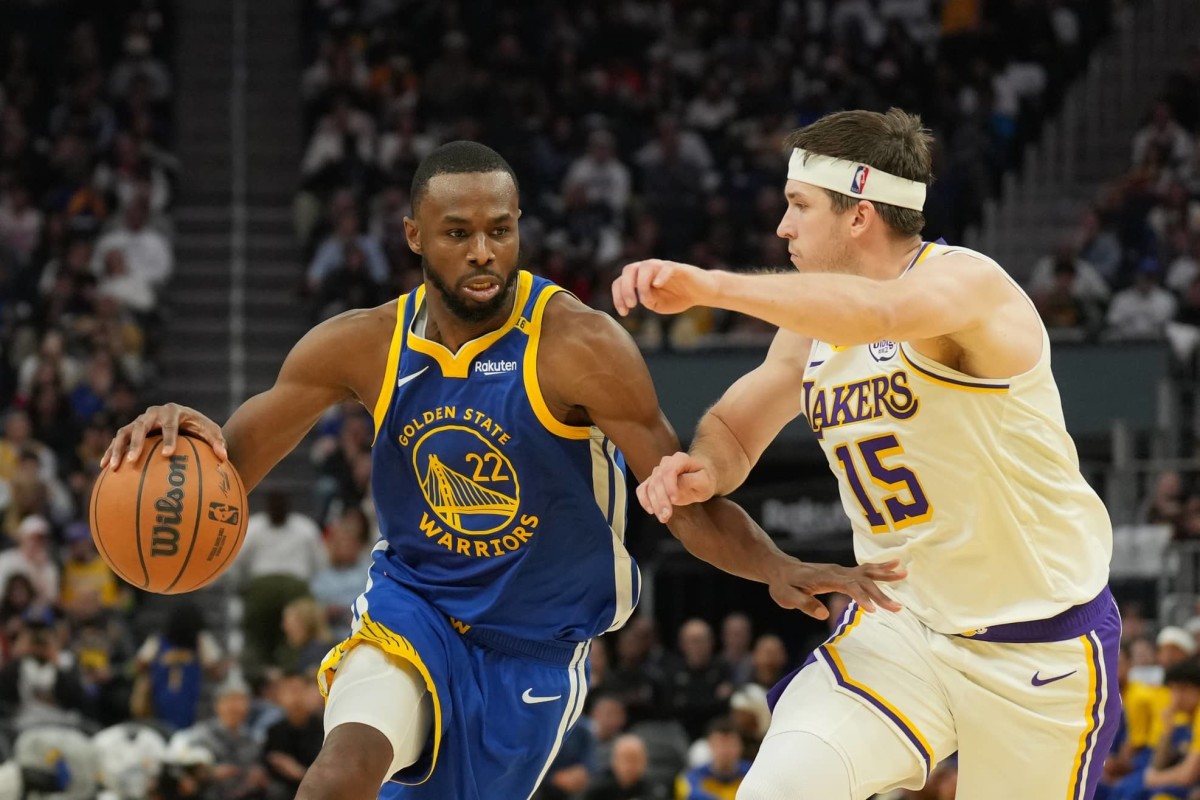 Dec 25, 2024; San Francisco, California, USA; Golden State Warriors forward Andrew Wiggins (22) dribbles against Los Angeles Lakers guard Austin Reaves (15) during the third quarter at Chase Center.