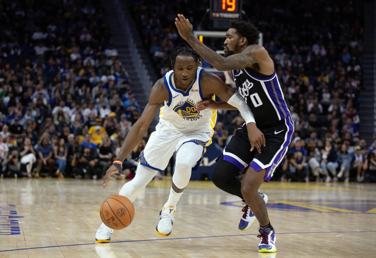 Oct 18, 2023; San Francisco, California, USA; Golden State Warriors forward Jonathan Kuminga (00) drives past Sacramento Kings guard Malik Monk (0) during the fourth quarter at Chase Center.