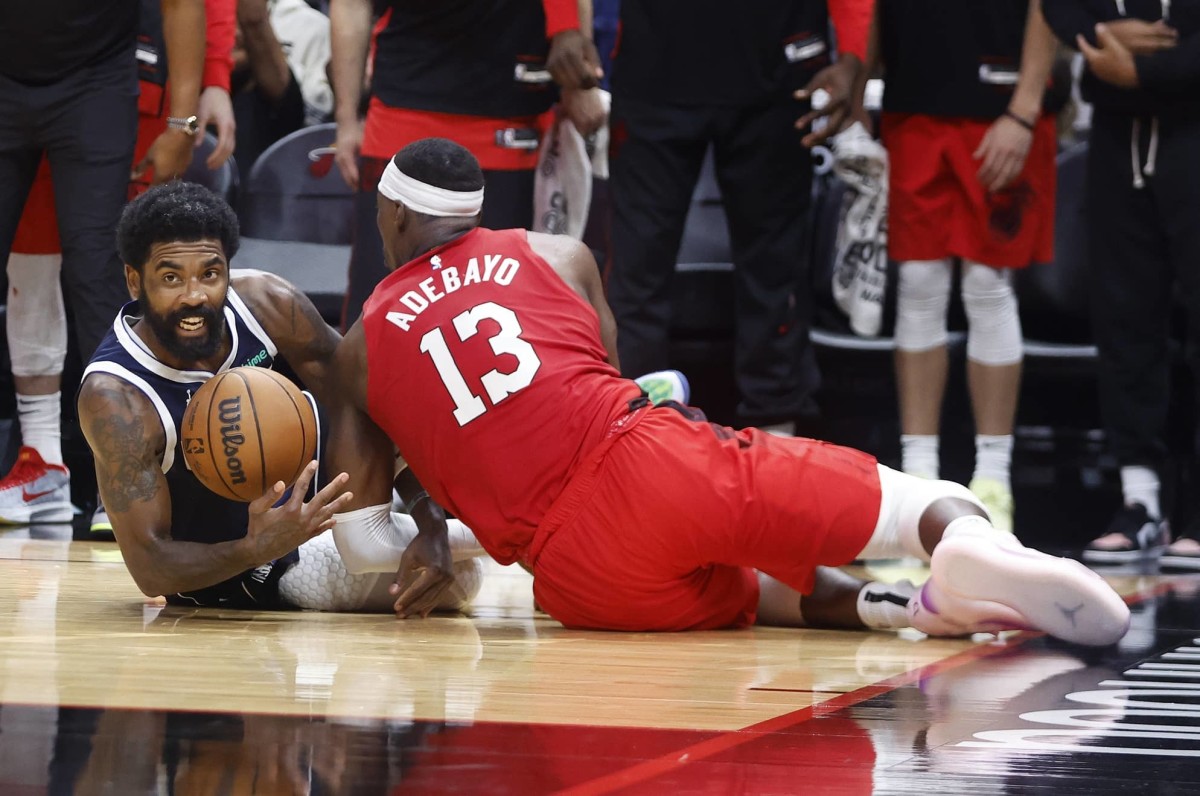 Nov 24, 2024; Miami, Florida, USA; Dallas Mavericks guard Kyrie Irving (11) and Miami Heat center Bam Adebayo (13) fight for a loose ball during the second half at Kaseya Center. Mandatory Credit: Rhona Wise-Imagn Images  