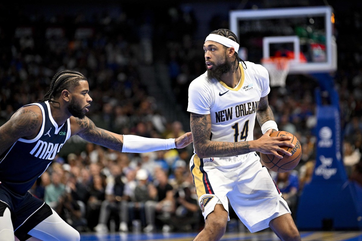 Nov 19, 2024; Dallas, Texas, USA; New Orleans Pelicans forward Brandon Ingram (14) looks to move the ball past Dallas Mavericks guard Jaden Hardy (1) during the first half at the American Airlines Center. Mandatory Credit: Jerome Miron-Imagn Images 