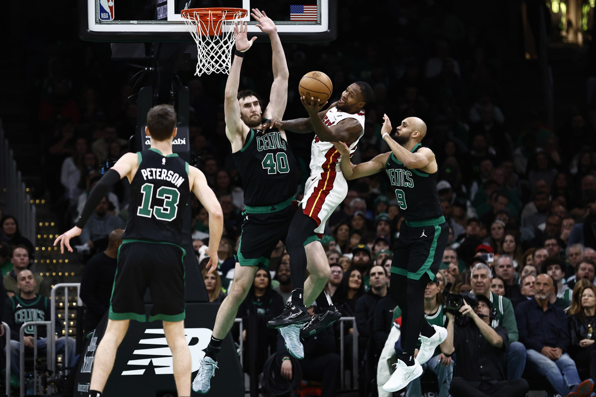 Dec 2, 2024; Boston, Massachusetts, USA; Miami Heat forward Haywood Highsmith (24) grabs a rebound against Boston Celtics center Luke Kornet (40) during the second half at TD Garden. Mandatory Credit: Winslow Townson-Imagn Images  