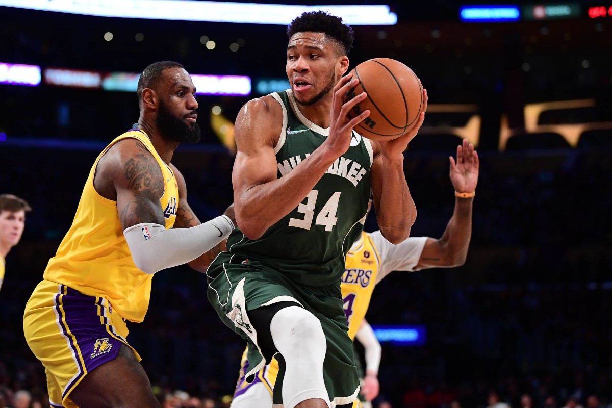 Los Angeles, California, USA; Milwaukee Bucks forward Giannis Antetokounmpo (34) moves the ball against Los Angeles Lakers forward LeBron James (6) during the second half at Crypto.com Arena. Mandatory Credit: Gary A. Vasquez-Imagn Images