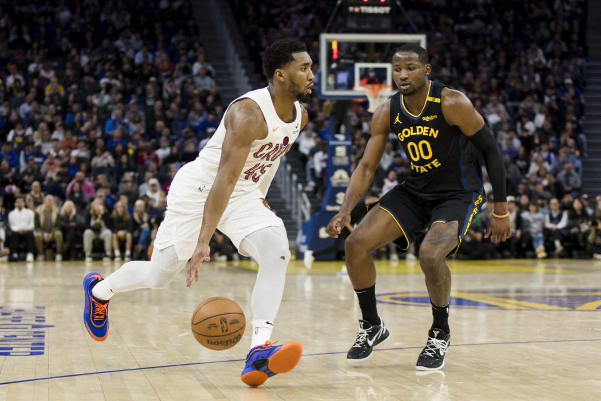 Dec 30, 2024; San Francisco, California, USA; Cleveland Cavaliers guard Donovan Mitchell (45) drives past Golden State Warriors forward Jonathan Kuminga (00) during the fourth quarter at Chase Center. Mandatory Credit: John Hefti-Imagn Images