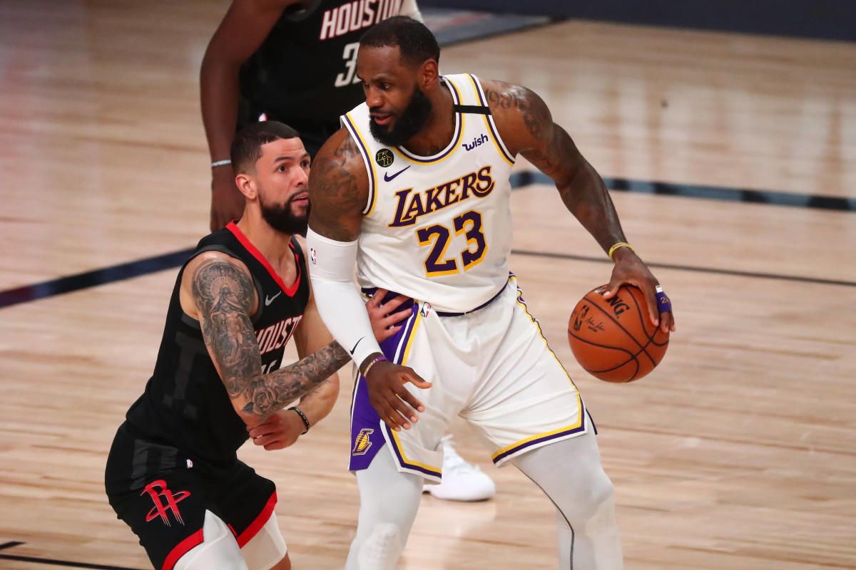 Lake Buena Vista, Florida, USA; Los Angeles Lakers forward LeBron James (23) dribbles the ball against Houston Rockets guard Austin Rivers (left) during the second half of game three in the second round of the 2020 NBA Playoffs at AdventHealth Arena. Mandatory Credit: Kim Klement-Imagn Images