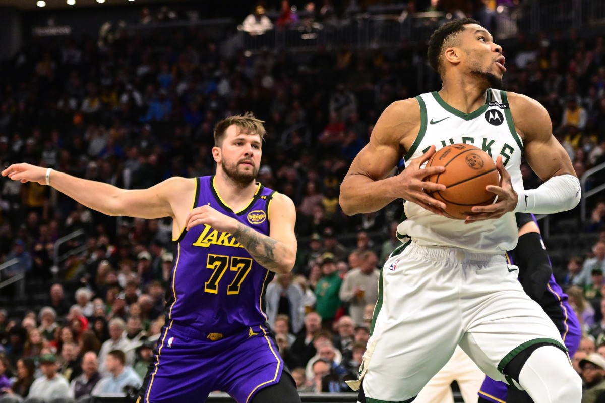 Milwaukee Bucks forward Giannis Antetokounmpo (34) controls the ball against Los Angeles Lakers guard Luka Doncic (77) in the first quarter at Fiserv Forum. Mandatory Credit: Benny Sieu-Imagn Images