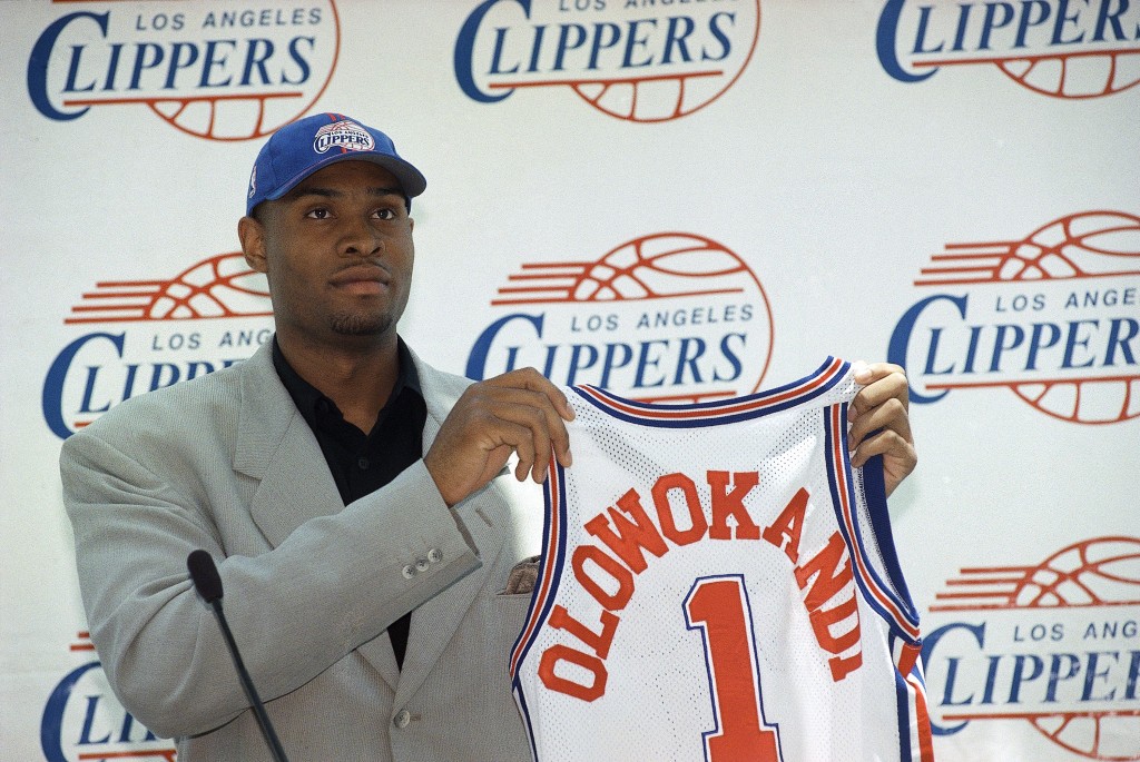 Michael Olowokandi, the first pick in Wednesday's NBA draft, holds a Los Angeles Clippers jersey during a news conference in Los Angeles on Thursday, June 25, 1998. Olowokandi, a 7-foot-1 Nigerian who grew up in England and has been playing competitive basketball for only three years, played last season at Pacific University. (AP Photo/Nick Ut)