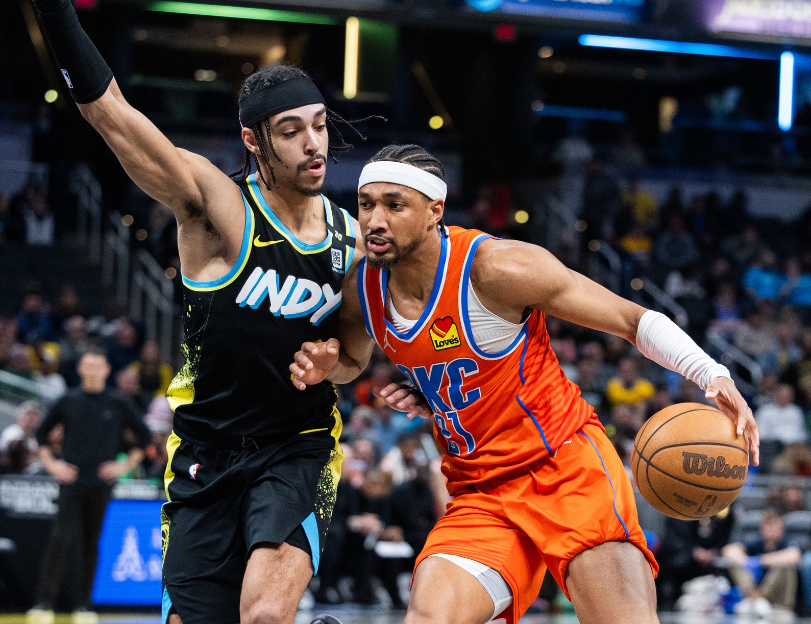 Indianapolis, Indiana, USA; Oklahoma City Thunder guard Aaron Wiggins (21) dribbles the ball while Indiana Pacers guard Andrew Nembhard (2) defends in the second half at Gainbridge Fieldhouse.