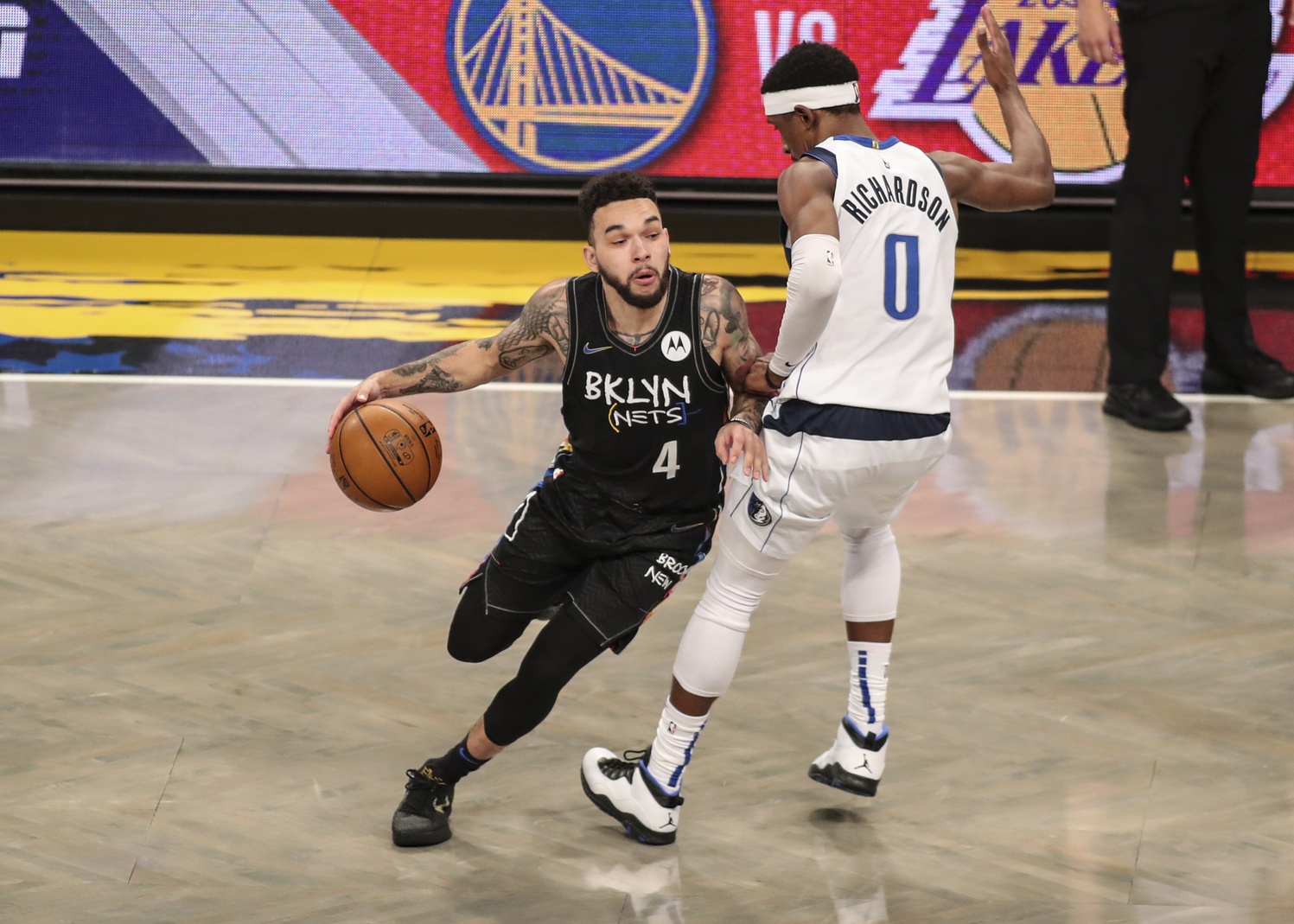 Feb 27, 2021; Brooklyn, New York, USA; Brooklyn Nets guard Chris Chiozza (4) drives past Dallas Mavericks guard Josh Richardson (0) in the fourth quarter at Barclays Center.