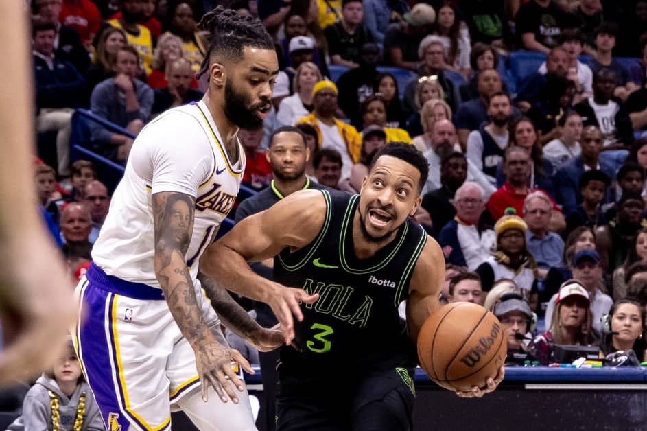 Apr 14, 2024; New Orleans, Louisiana, USA; New Orleans Pelicans guard CJ McCollum (3) dribbles against Los Angeles Lakers guard D'Angelo Russell (1) during the first half at Smoothie King Center.