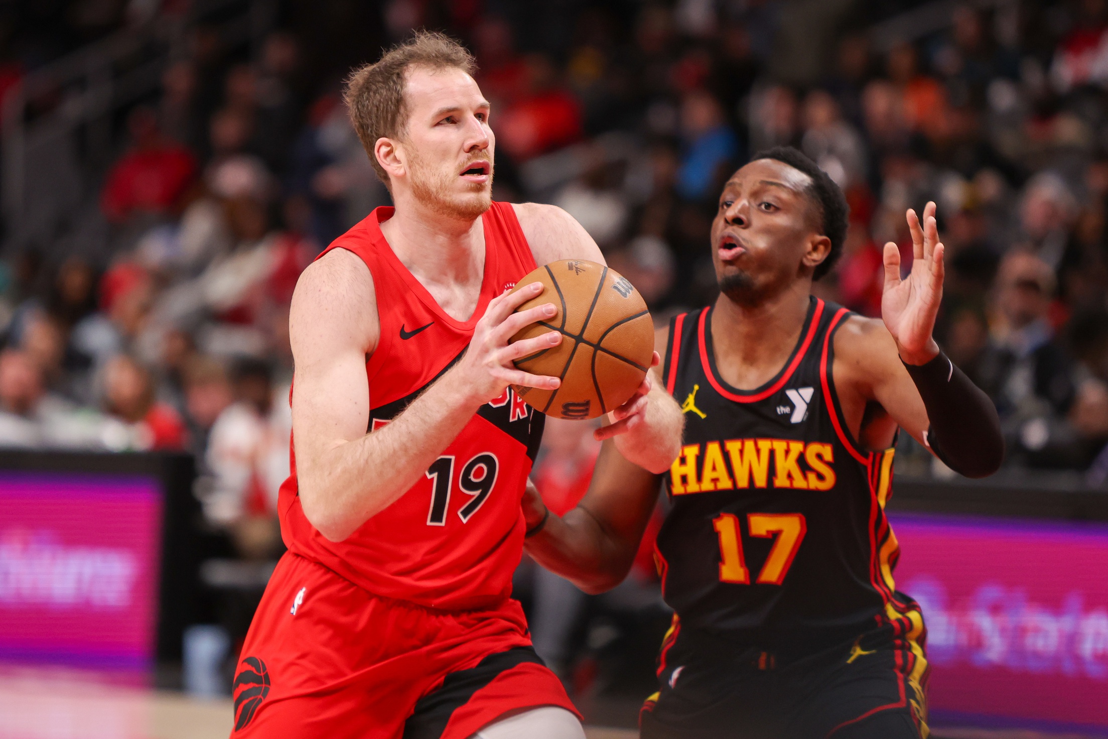 Toronto Raptors center Jakob Poeltl (19) drives on Atlanta Hawks forward Onyeka Okongwu (17) in the third quarter at State Farm Arena. Mandatory Credit: Brett Davis-Imagn Images