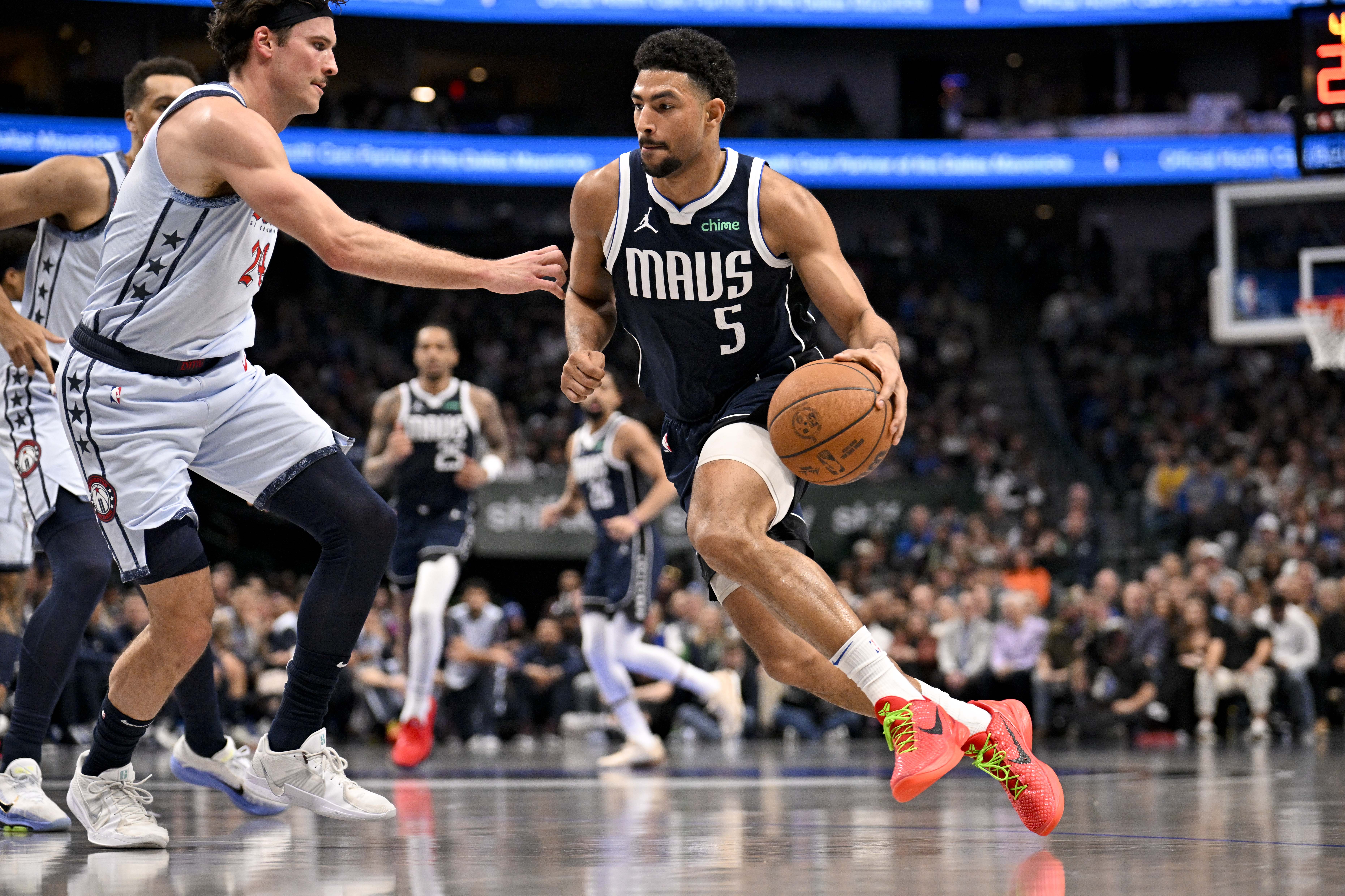 Jan 27, 2025; Dallas, Texas, USA; Dallas Mavericks guard Quentin Grimes (5) drives to the basket against Washington Wizards forward Corey Kispert (24) during the second quarter at the American Airlines Center. Mandatory Credit: Jerome Miron-Imagn Images