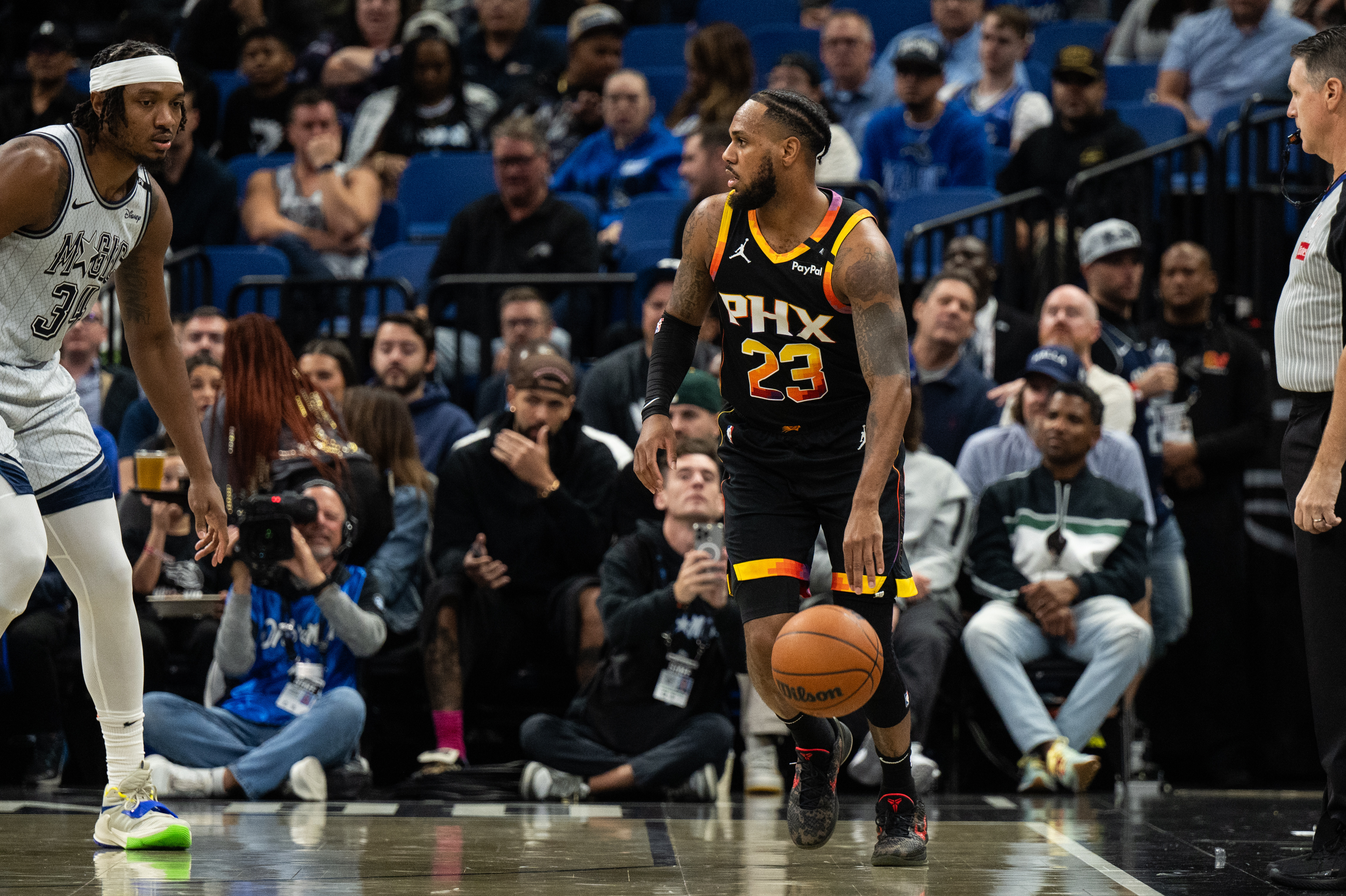 Dec 8, 2024; Orlando, Florida, USA; Phoenix Suns guard Monté Morris (23) dribbles the ball against Orlando Magic forward Wendell Carter Jr. in the second quarter at Kia Center. Mandatory Credit: Jeremy Reper-Imagn Images
