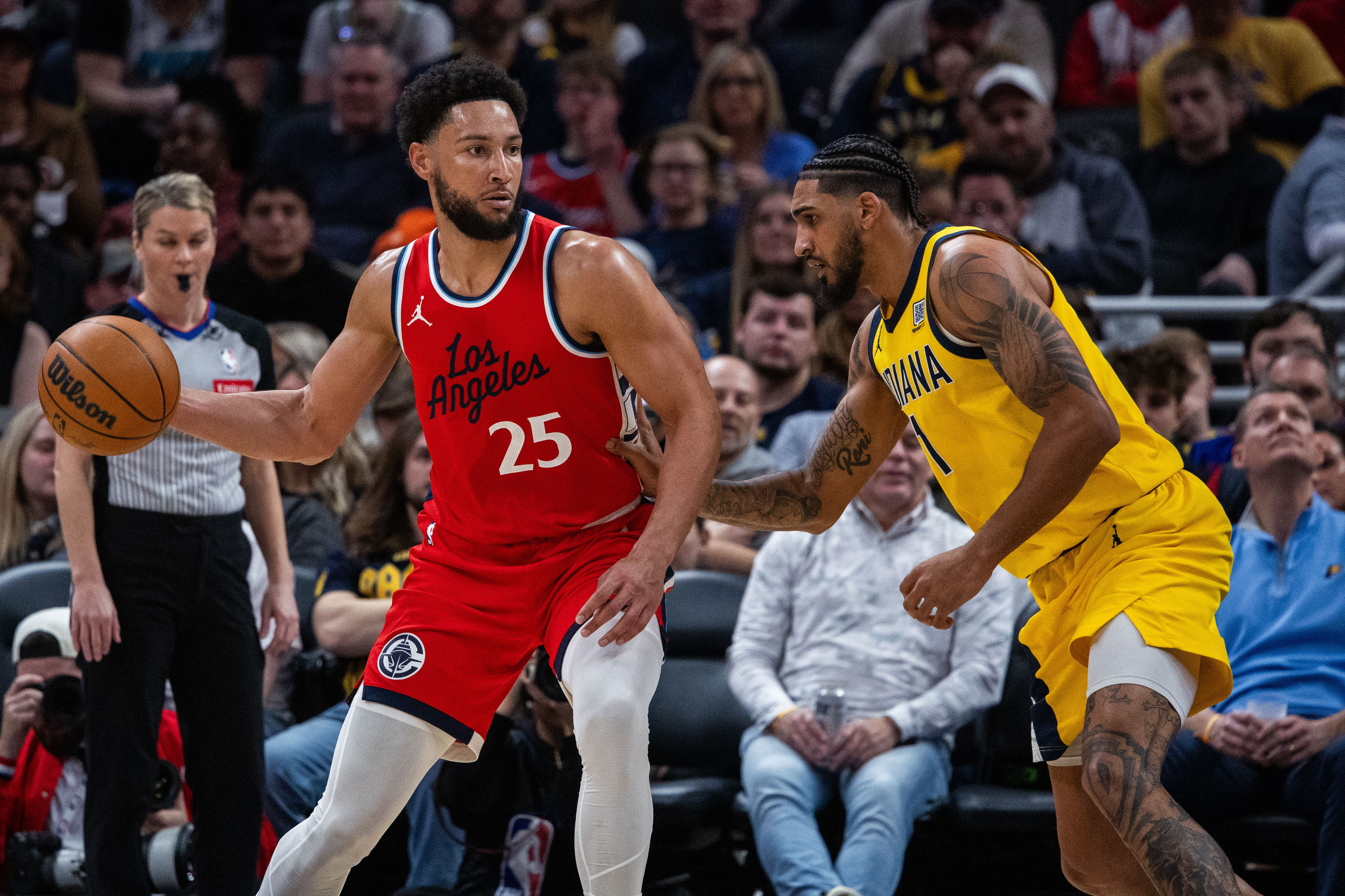 Feb 23, 2025; Indianapolis, Indiana, USA; LA Clippers guard Ben Simmons (25) dribbles the ball while Indiana Pacers forward Obi Toppin (1) defends in the second half at Gainbridge Fieldhouse. Mandatory Credit: Trevor Ruszkowski-Imagn Images