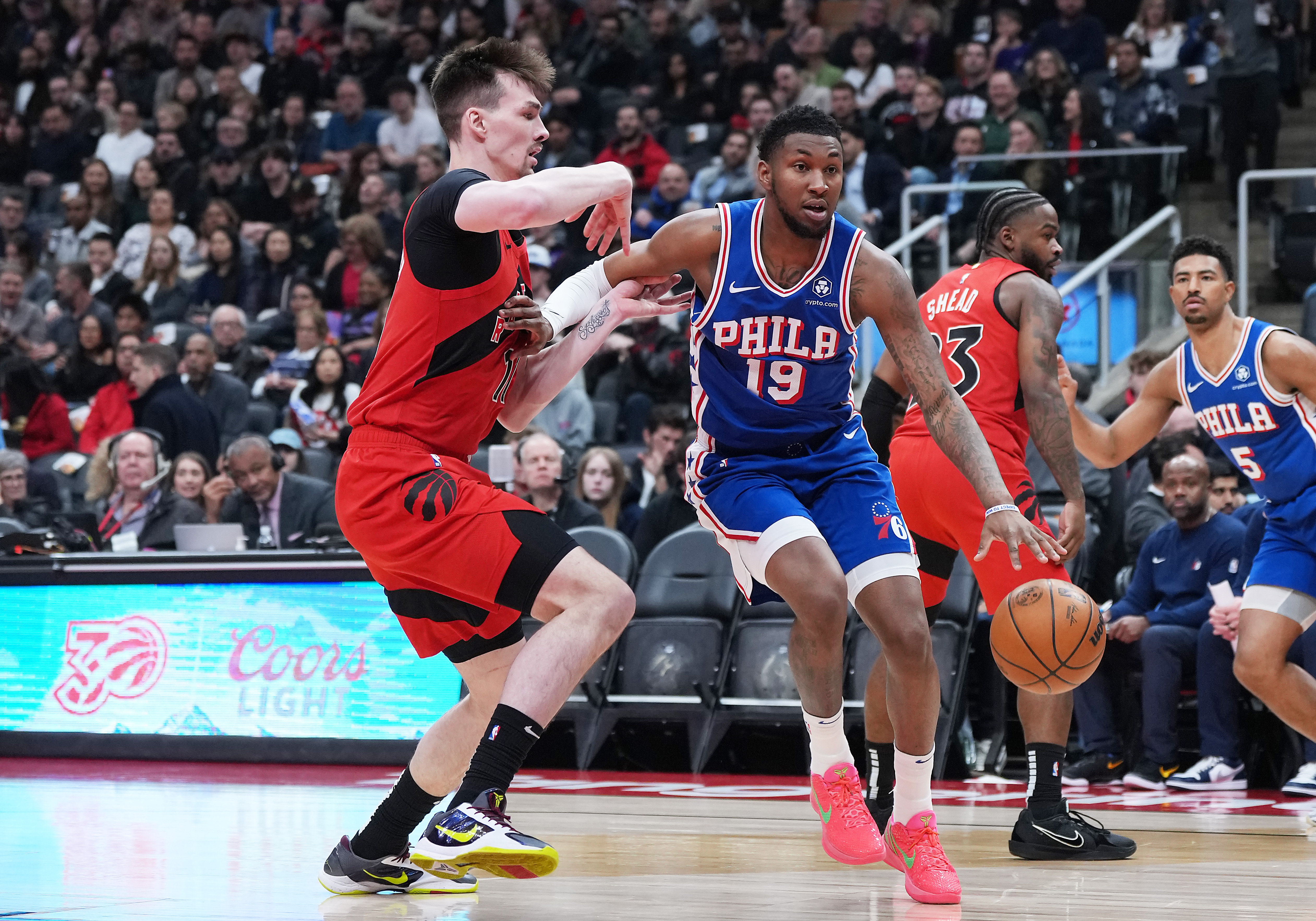 Mar 12, 2025; Toronto, Ontario, CAN; Philadelphia 76ers forward Justin Edwards (19) controls the ball as Toronto Raptors center Colin Castleton (11) tries to defend during the first quarter at the Scotiabank Arena. Mandatory Credit: Nick Turchiaro-Imagn Images