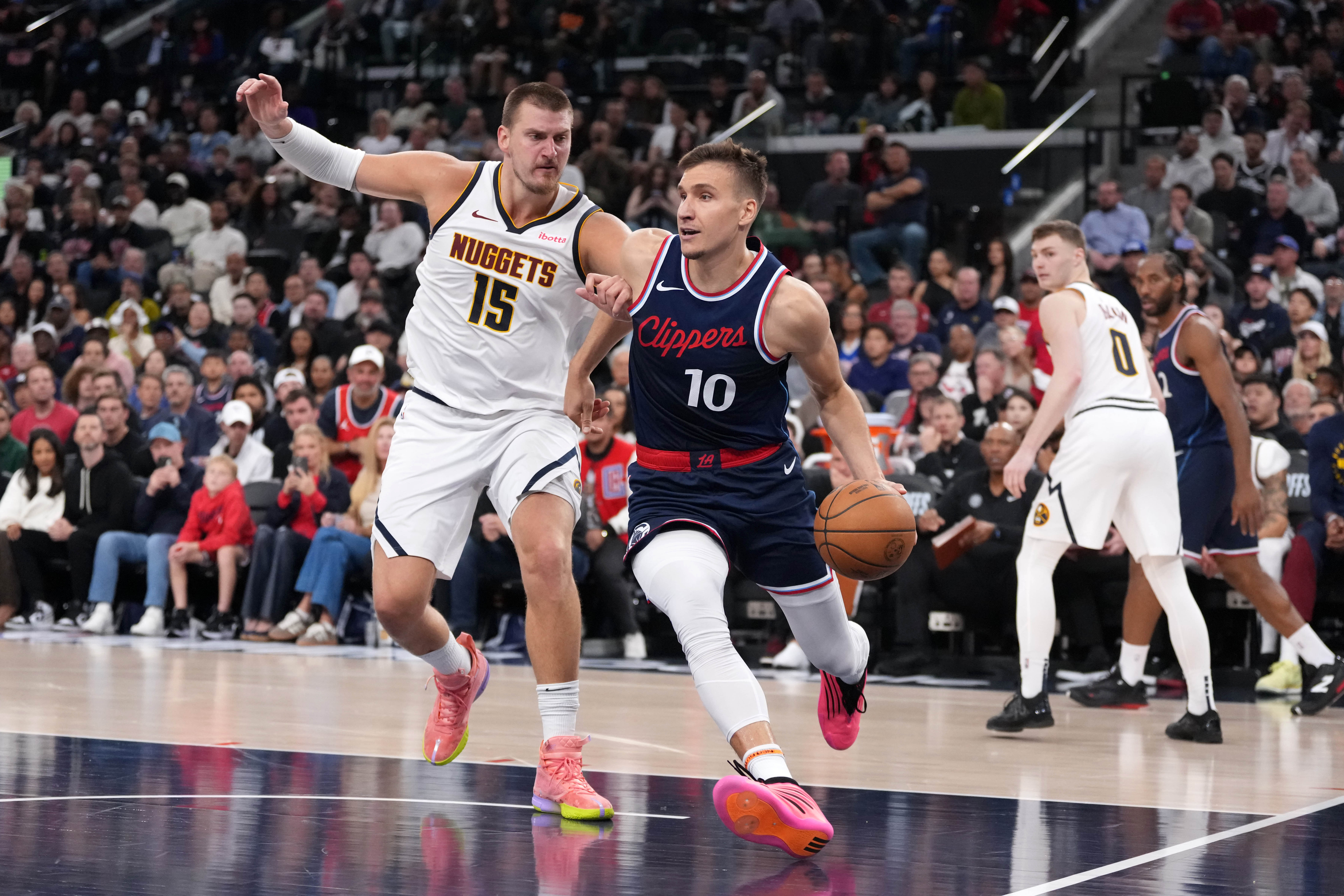 May 1, 2025; Inglewood, California, USA; LA Clippers guard Bogdan Bogdanovic (10) dribbles the ball against Denver Nuggets center Nikola Jokic (15) in the second half during game six of first round for the 2025 NBA Playoffs at Intuit Dome. Mandatory Credit: Kirby Lee-Imagn Images