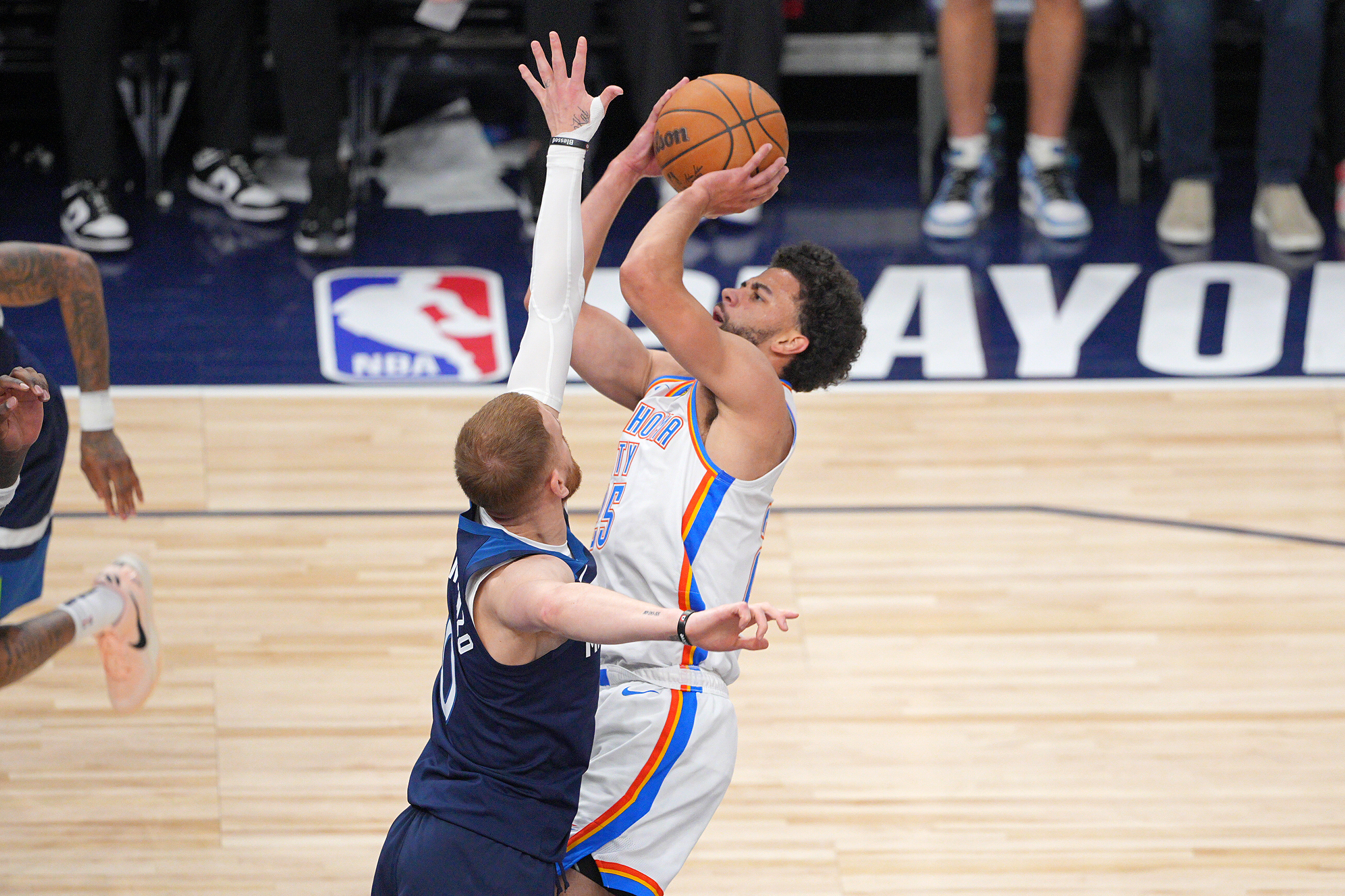 May 24, 2025; Minneapolis, Minnesota, USA; Minnesota Timberwolves guard Donte DiVincenzo (0) fouls Oklahoma City Thunder guard Ajay Mitchell (25) during the second half in game three of the western conference finals for the 2025 NBA Playoffs at Target Center. Mandatory Credit: Brad Rempel-Imagn Images