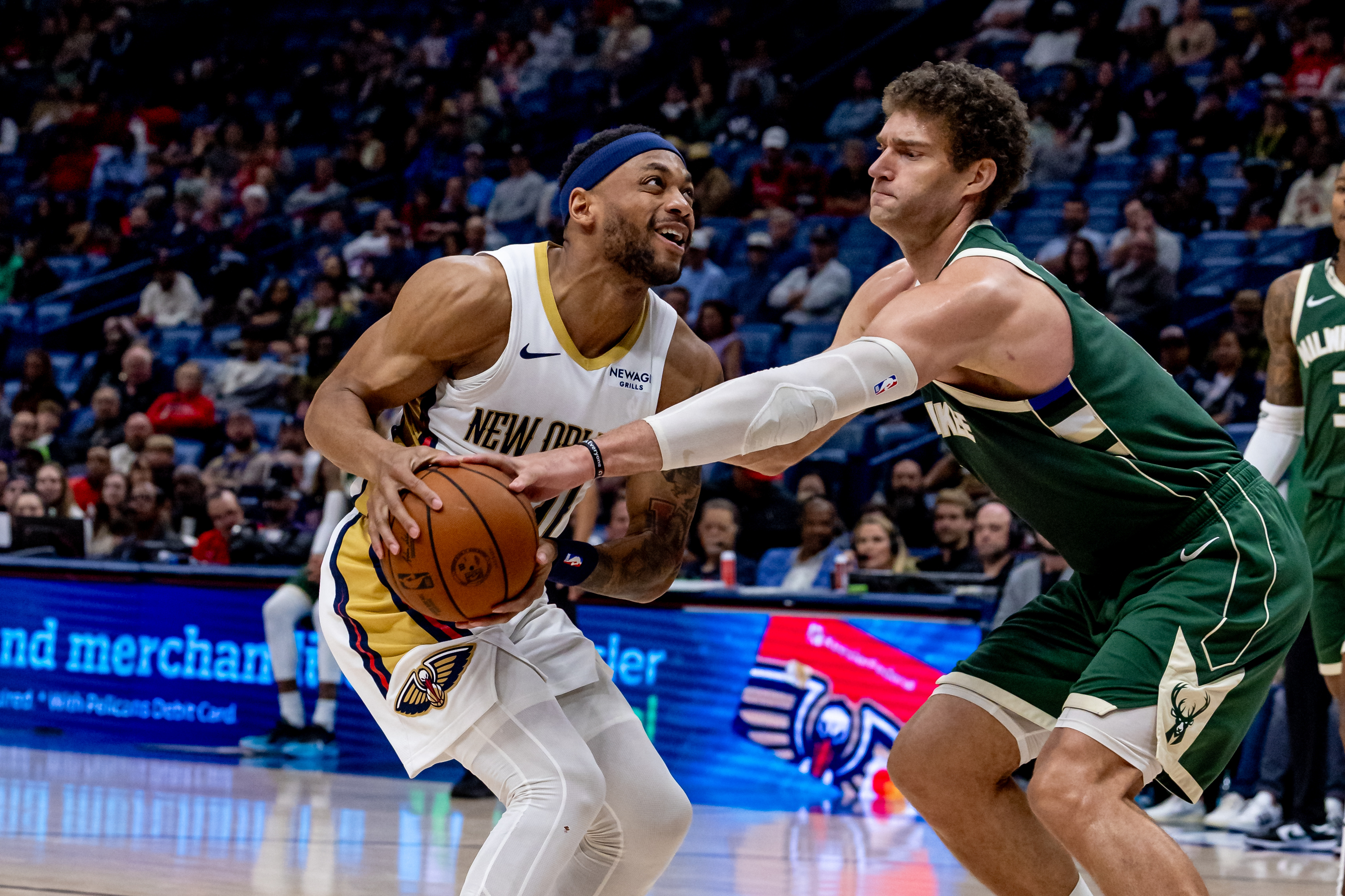 Apr 6, 2025; New Orleans, Louisiana, USA; New Orleans Pelicans forward Bruce Brown (00) has the ball knocked loose by Milwaukee Bucks center Brook Lopez (11) during the second half at Smoothie King Center. Mandatory Credit: Stephen Lew-Imagn Images