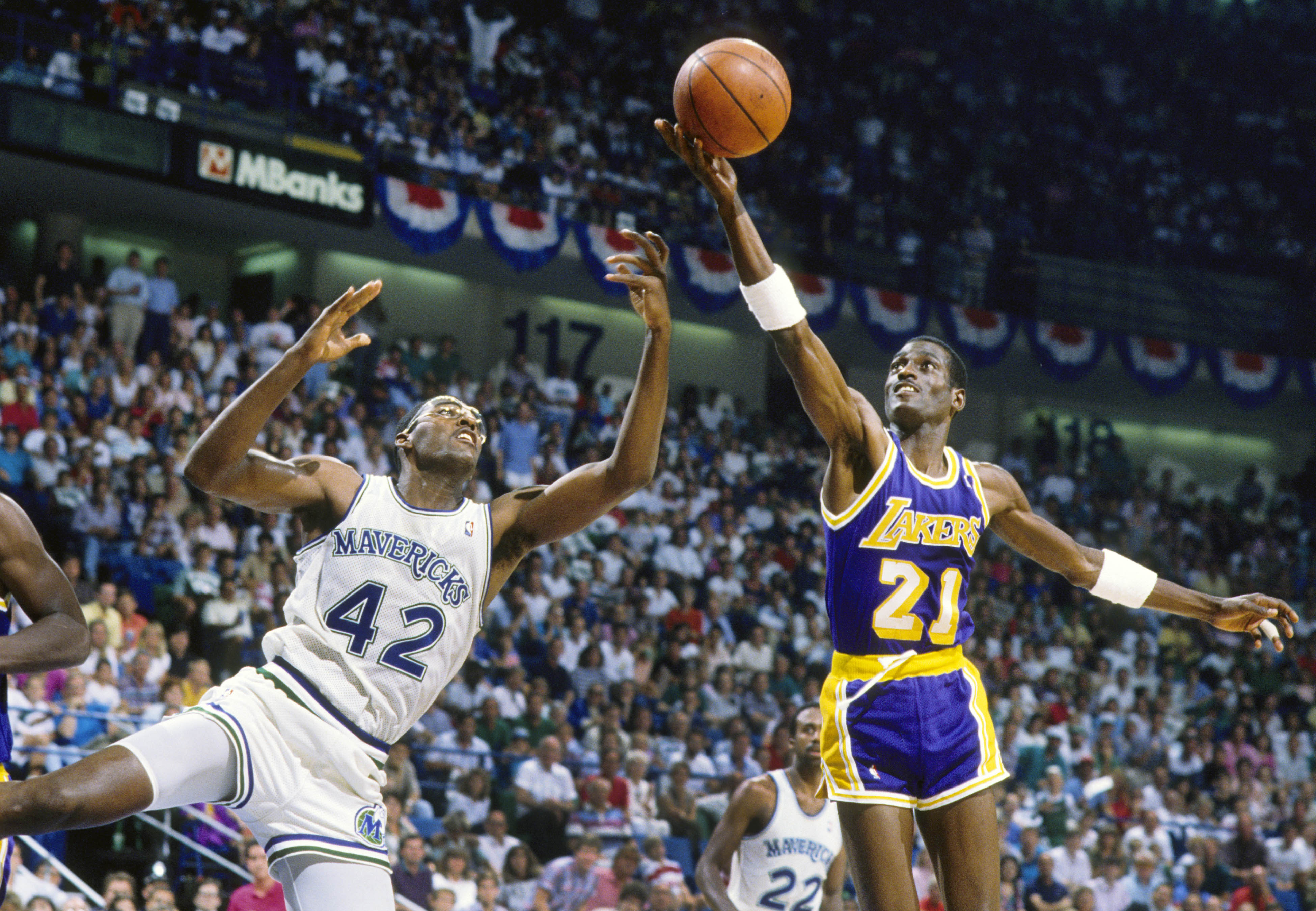 May 1988; Dallas, TX, USA; FILE PHOTO; Los Angeles Lakers forward Michael Cooper (21) shoots over Dallas Mavericks forward Roy Tarpley (42) during the 1988 NBA Western Conference Finals at Reunion Arena. Mandatory Credit: MPS-Imagn Images  
