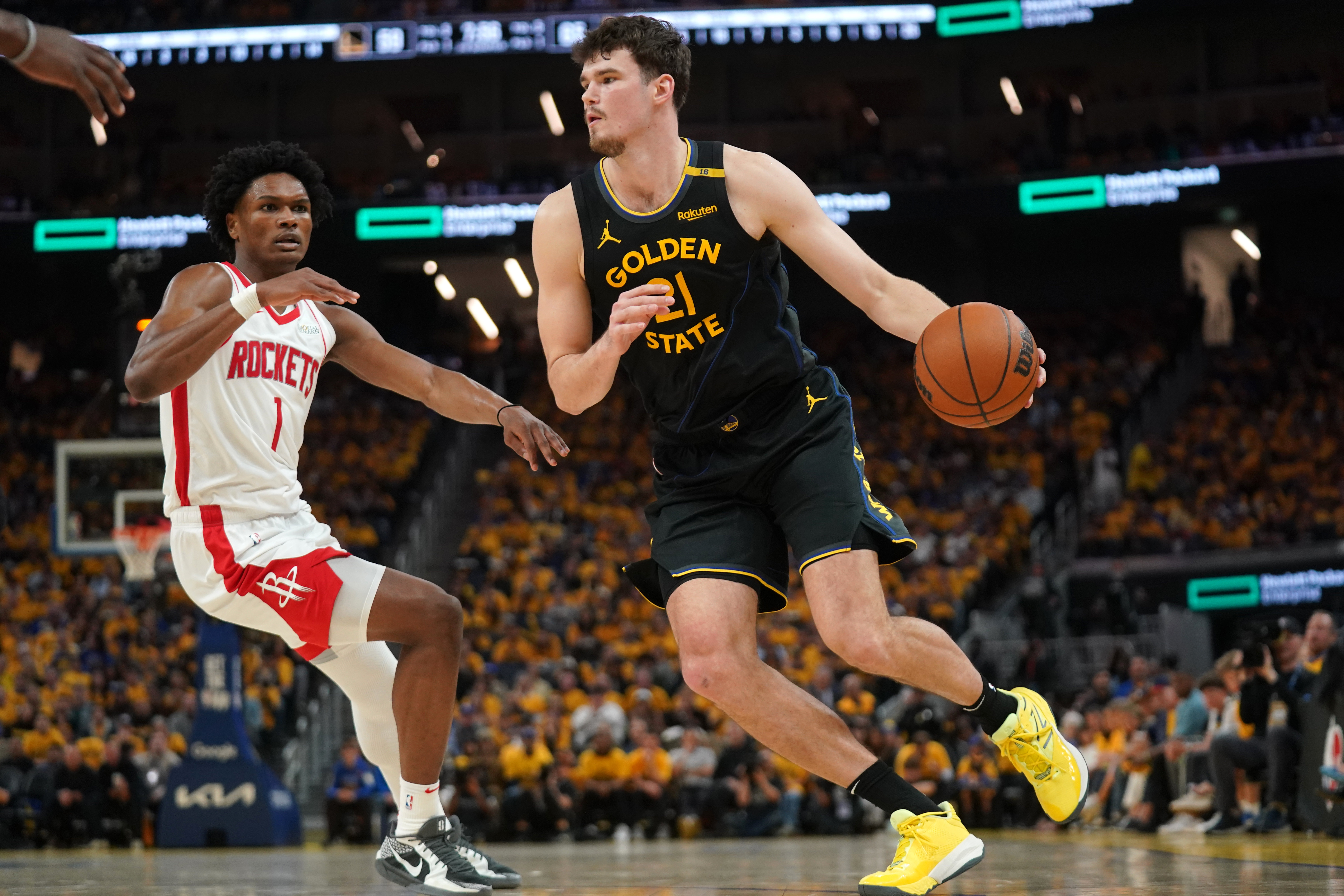 May 2, 2025; San Francisco, California, USA; Golden State Warriors center Quinten Post (21) dribbles past Houston Rockets forward Amen Thompson (1) in the third quarter of game six of the first round for the 2025 NBA Playoffs at Chase Center. Mandatory Credit: Cary Edmondson-Imagn Images