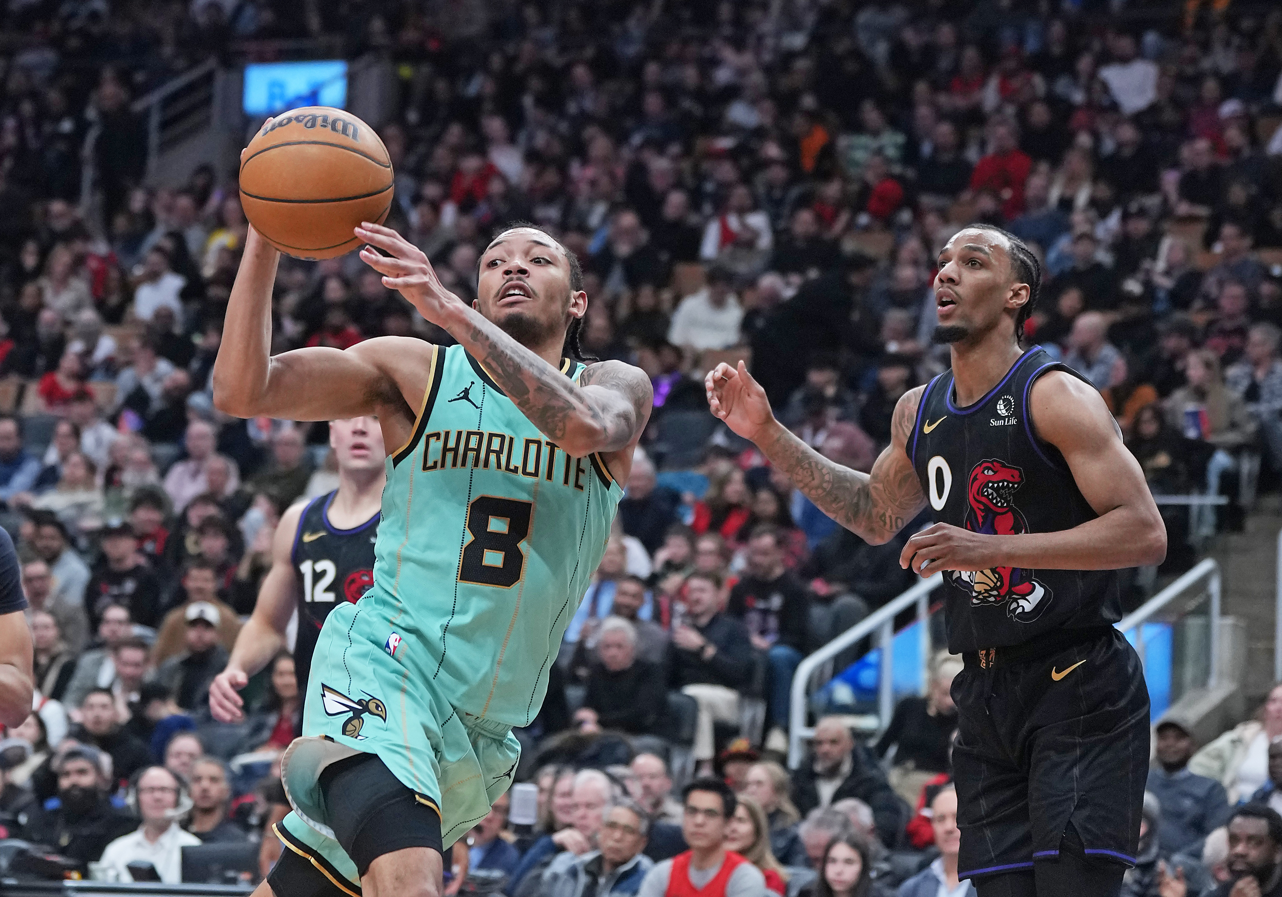 Apr 9, 2025; Toronto, Ontario, CAN; Charlotte Hornets guard Nick Smith Jr. (8) passes against Toronto Raptors guard A.J. Lawson (0) during the third quarter at Scotiabank Arena. Mandatory Credit: Nick Turchiaro-Imagn Images