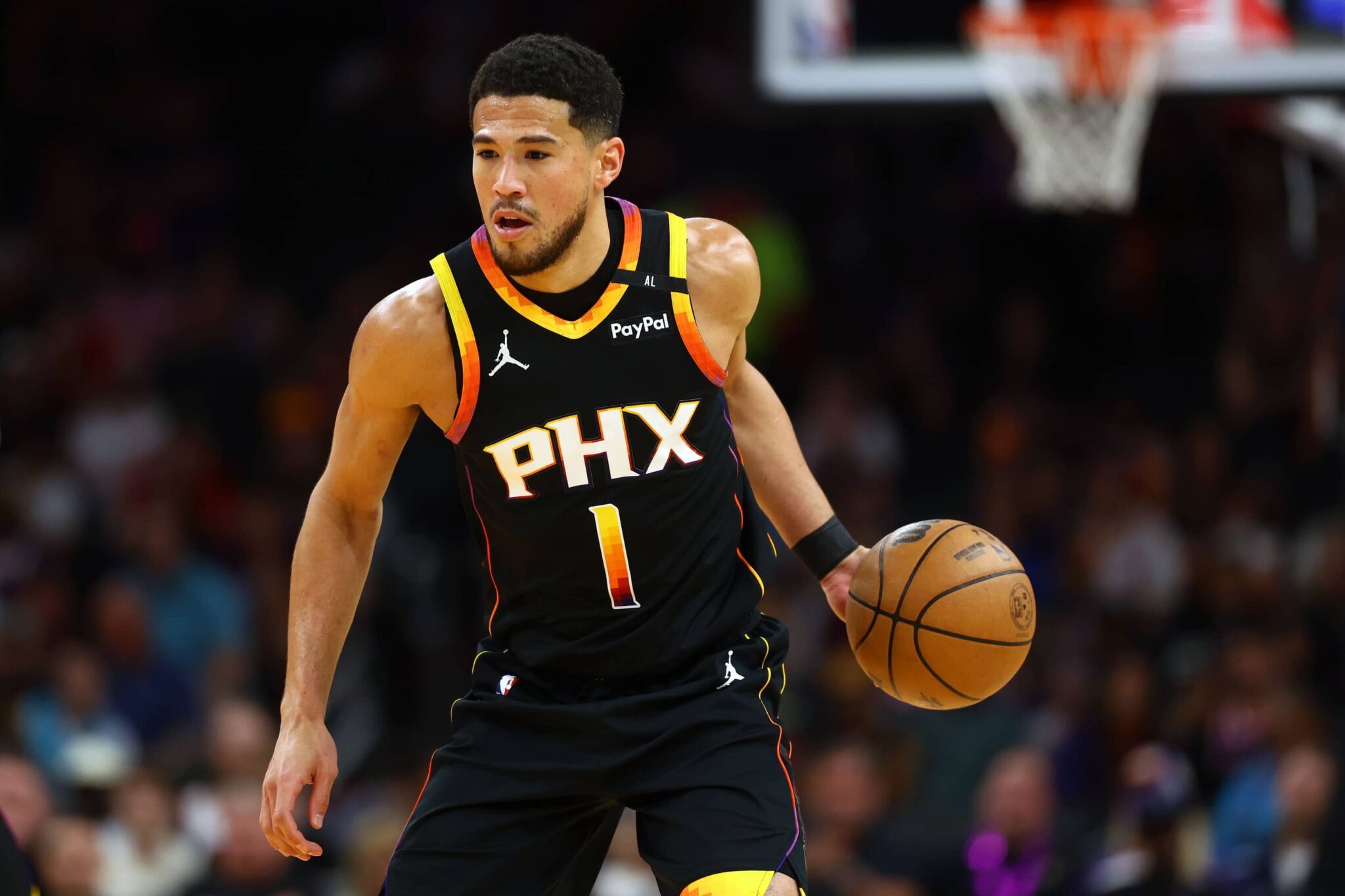 Devin Booker dribbles during a game between the Phoenix Suns and Oklahoma City Thunder.