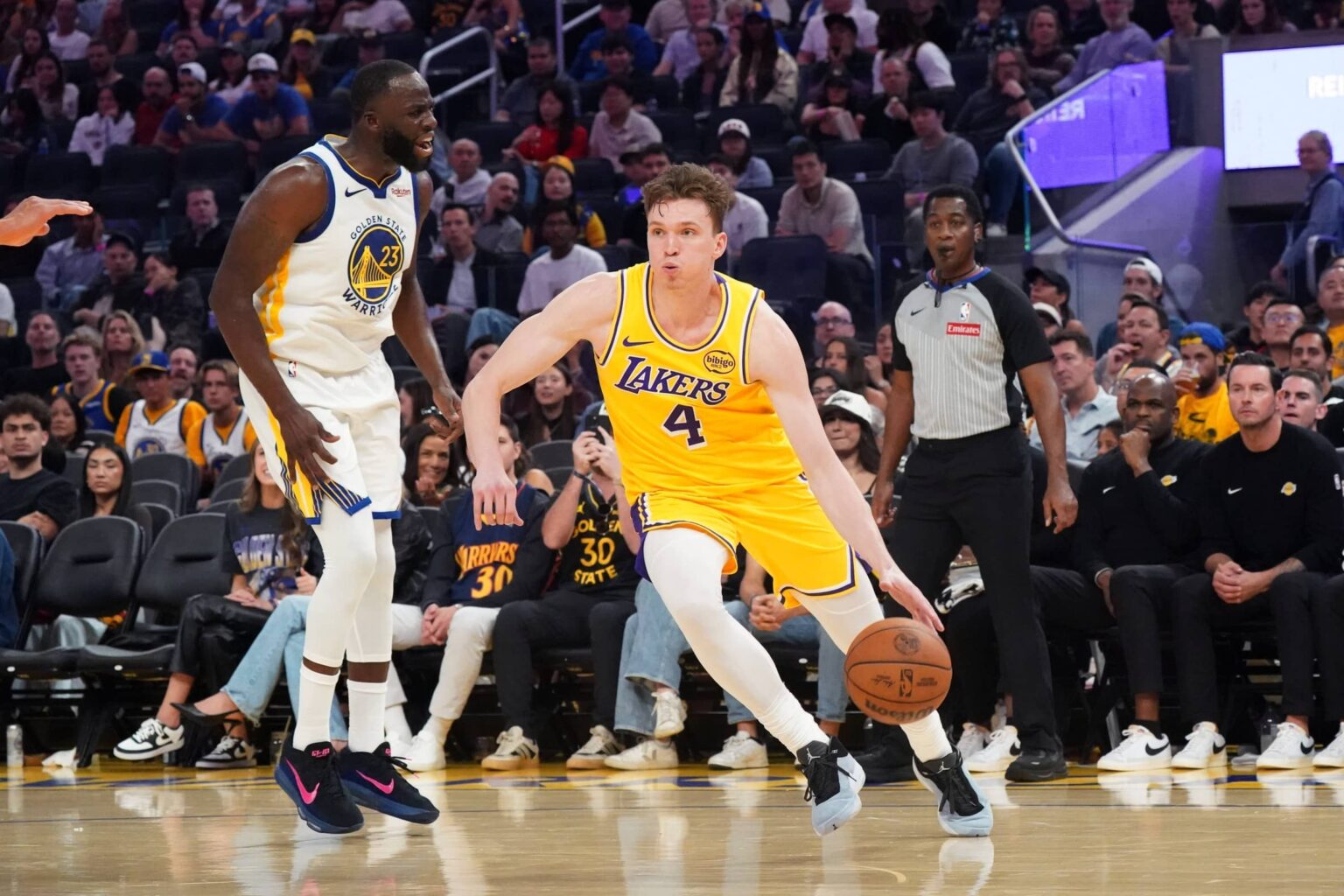 Lakers forward Dalton Knecht dribbles by Warriors forward Draymond Green in the second quarter at Chase Center