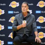 Lakers general manager Rob Pelinka, left, speaks during a press conference to preview the 2025-26 season at UCLA Health Training Center.