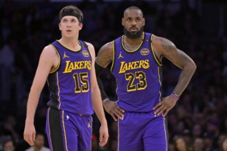 Lakers guard Austin Reaves and forward LeBron James talk on the court against the Nets at Crypto.com Arena