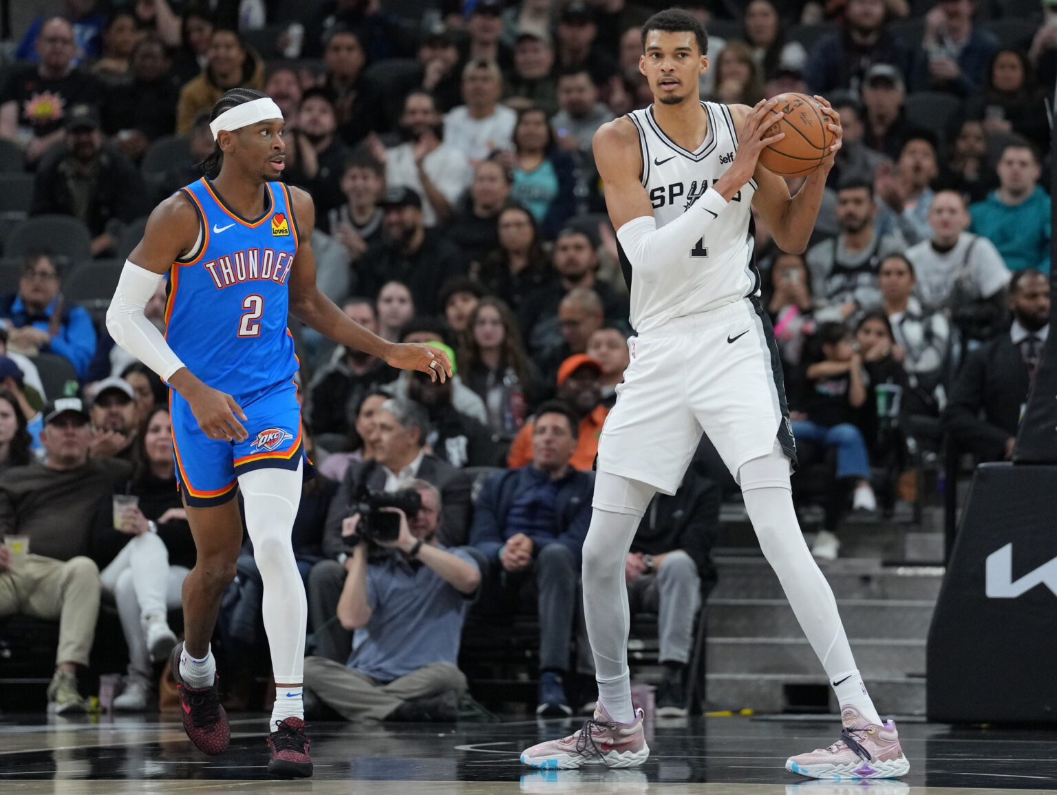Feb 29, 2024; San Antonio, Texas, USA; San Antonio Spurs center Victor Wembanyama (1) looks down the court beside Oklahoma City Thunder guard Shai Gilgeous-Alexander (2) in the first half at Frost Bank Center. Mandatory Credit: Daniel Dunn-Imagn Images
