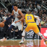 Nov 27, 2024; San Antonio, Texas, USA; San Antonio Spurs center Victor Wembanyama (1) dribbles past Los Angeles Lakers forward LeBron James (23) in the first half at Frost Bank Center. Mandatory Credit: Daniel Dunn-Imagn Images