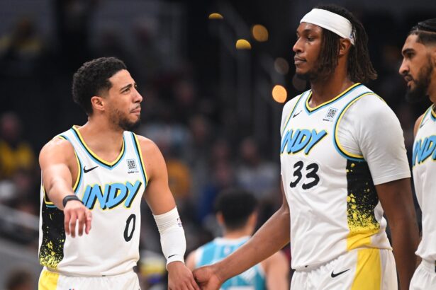 Dec 8, 2024; Indianapolis, Indiana, USA; Indiana Pacers guard Tyrese Haliburton (0) and Indiana Pacers center Myles Turner (33) talk during a timeout during the first half against the Charlotte Hornets at Gainbridge Fieldhouse. Mandatory Credit: Robert Goddin-Imagn Images